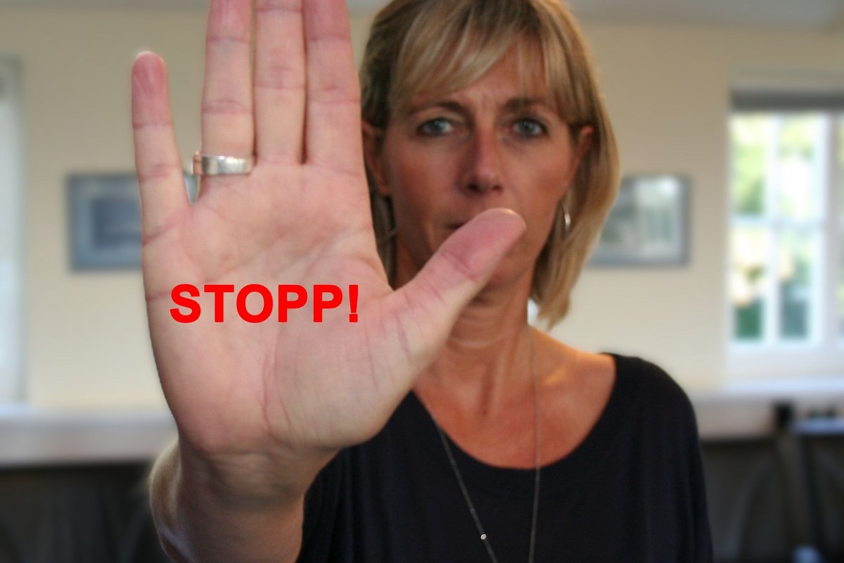 Fotomontage: Archiv - Felix Middendorf eine Frau hält ihre Hand abwehrend nach vorne. Zu sehen ist der Schriftzug: Stopp!