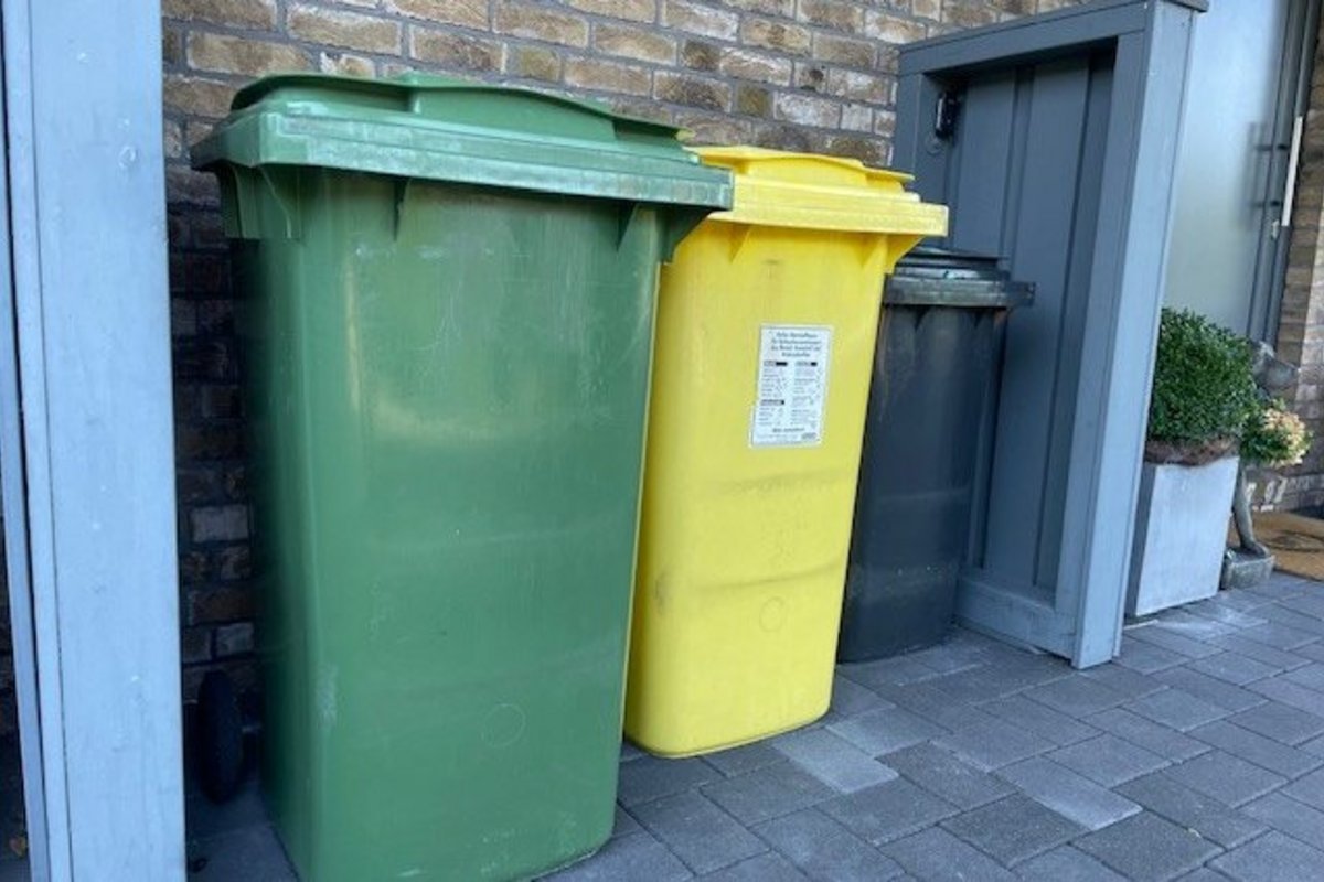 Drei Mülltonnen stehen nebeneinander