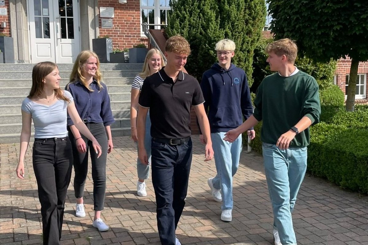 Sechs junge Menschen laufen und unterhalten sich.