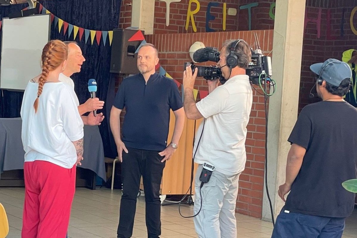 Ein Mann wird von einem Fernsehteam Interviewt.
