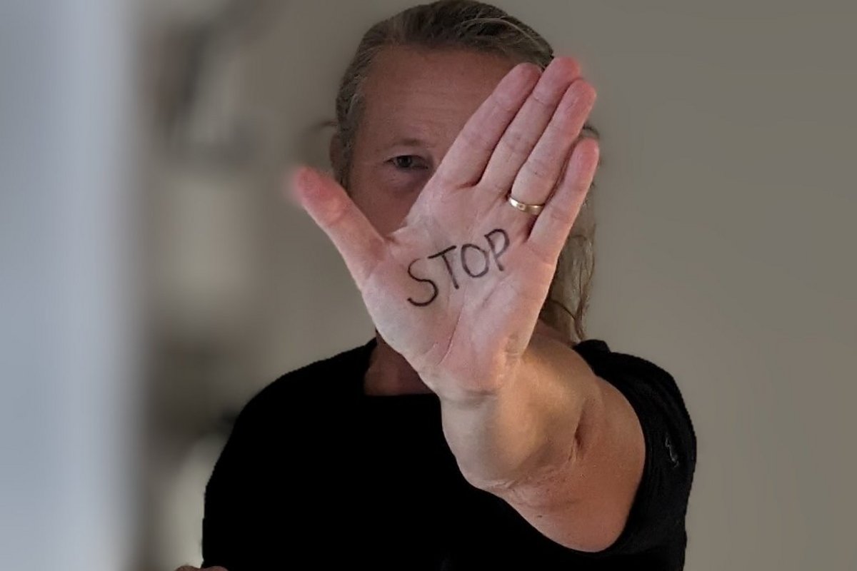 eine Frau signalisiert mit ausgestreckter Hand: Stopp!