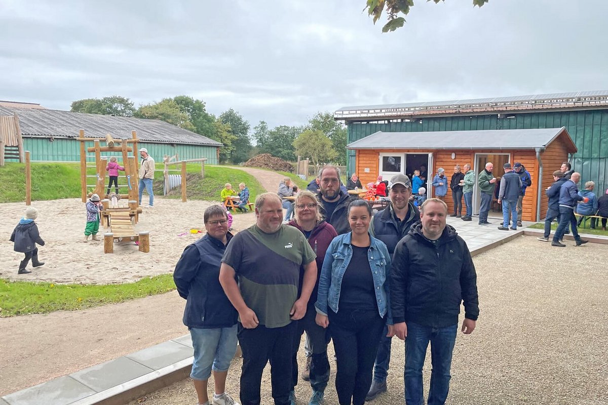 eine Gruppe Frauen und Männer steht auf einem Spielplatz