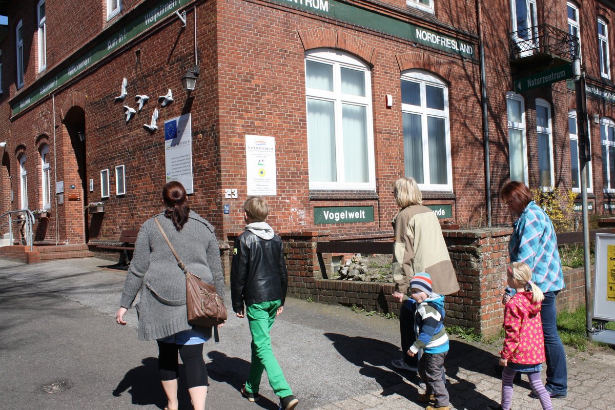 Mehrere Frauen und Kinder gehen auf ein Haus zu