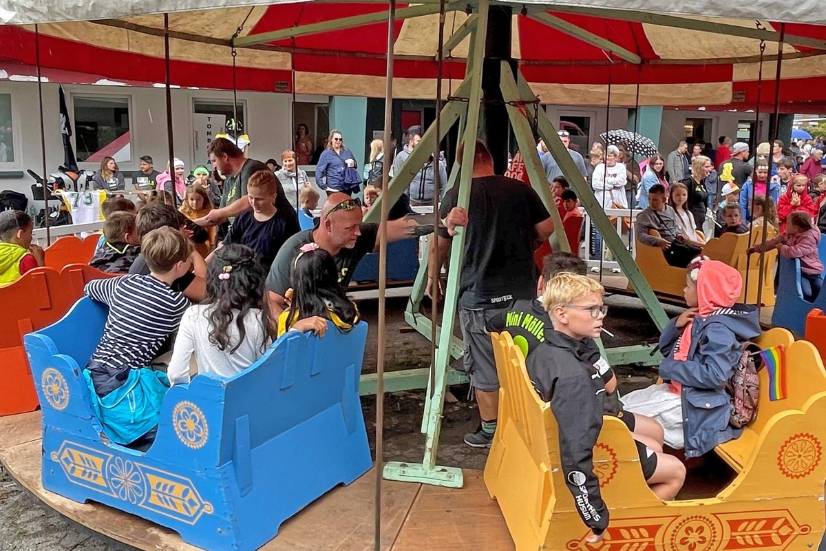 Kinder sitzen in einem bunten Karussel