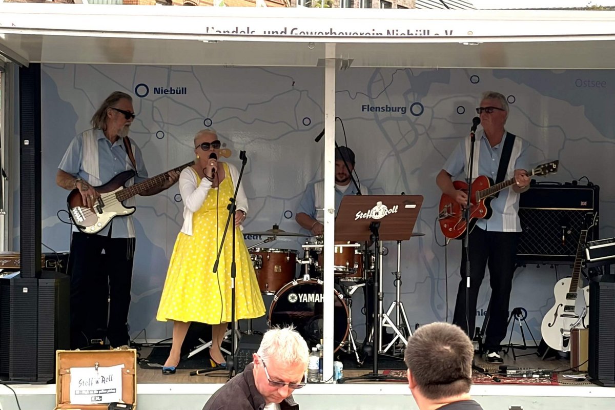 eine Frau und vier Männer machen Musik