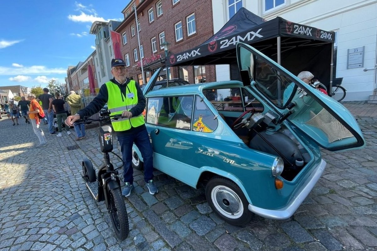 ein Mann steht vor einem Auto