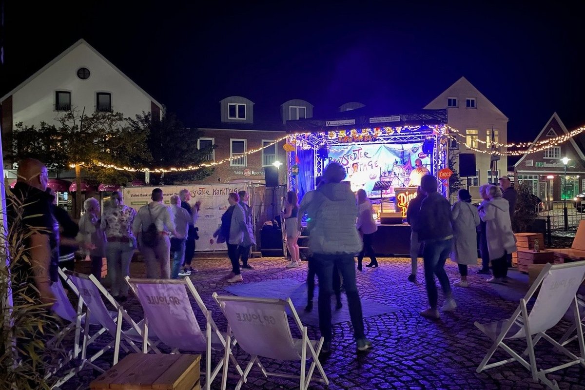 Menschen tanzen vor einer Bühne mit Musikern