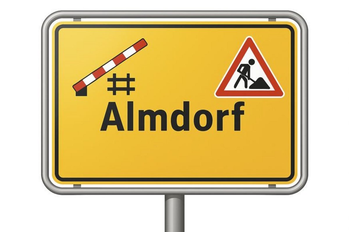 Das Ortsschild von Almdorf mit Baustellensymbolen