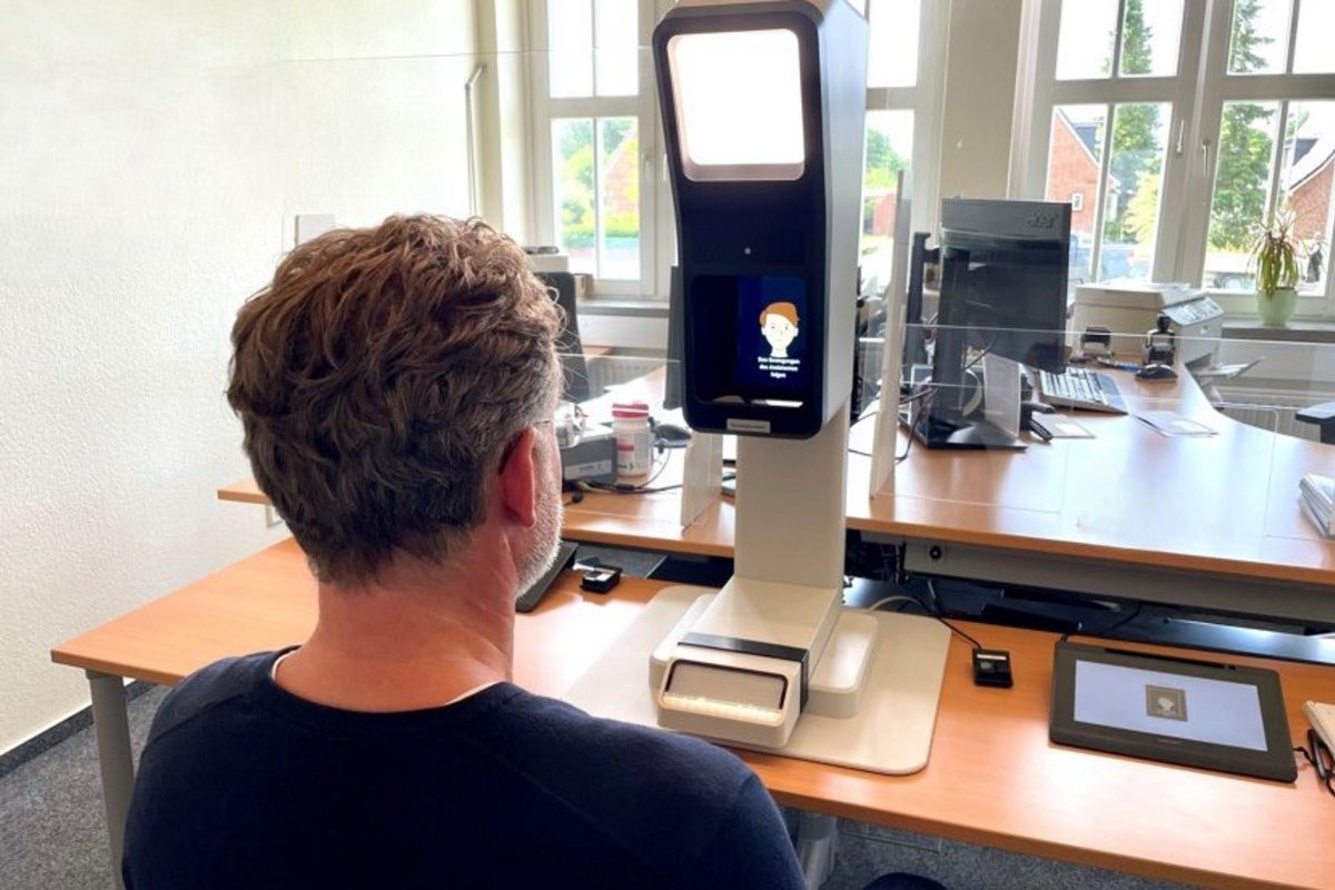 ein Mann sitzt vor einem großen Fotoapparat